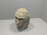 a sculpture of a man ' s head on a table