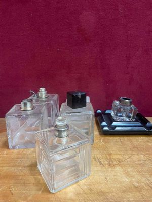 trois flacons de parfum posés sur une table à côté d'un téléphone portable