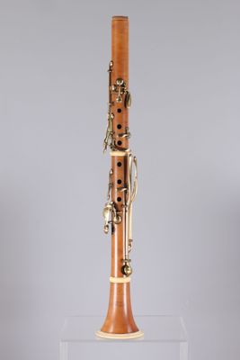 a close up of a bassoon on a stand on a grey background