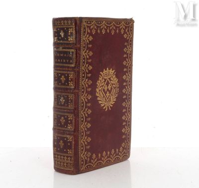 un vieux livre posé sur une table à côté d'un fond blanc