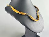 a close up of a necklace on a mannequin on a white background