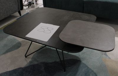 une table sur laquelle est posé un dessin, avec un canapé en arrière-plan