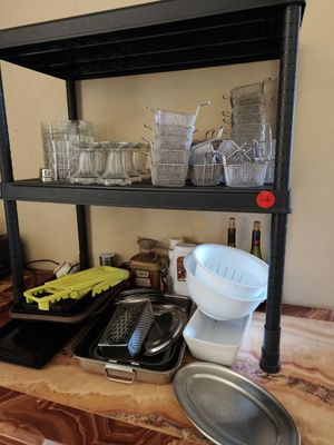 a shelf that has a bunch of dishes and pans on it