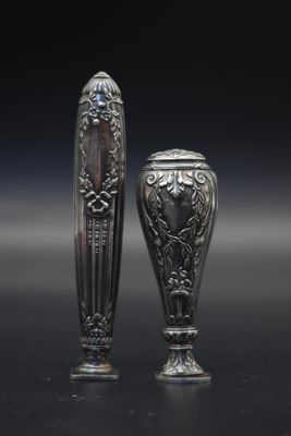 deux vases en argent posés l'un à côté de l'autre sur une table