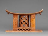 an old wooden stool with a carved design on top of it