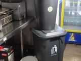 a trash can next to a trash can in a kitchen
