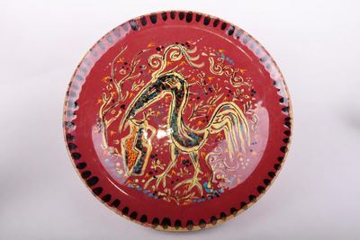 a red plate with a picture of a bird on it
