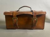 porte-documents en cuir marron avec des boucles en laiton sur fond blanc