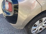the rear end of a silver car with a red light on it