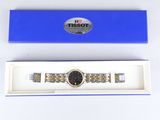 a close up of a watch in a blue box on a white surface