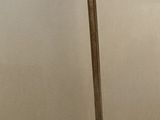 a metal pole with a wooden handle on a white table