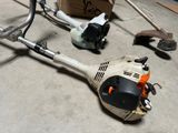 a picture of a lawn mower sitting on the floor next to a box of tools