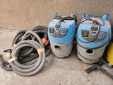 two vacuums and a hose sitting next to each other