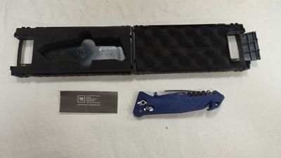 un couteau bleu et un étui noir posés sur une table