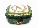 une boîte verte et dorée sur laquelle figure la lettre « n »