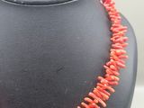 a necklace made of coral beads on a mannequin display