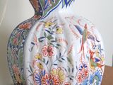 a vase that is sitting on a table with a lamp on it