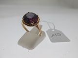 Gros plan sur une bague ornée d'une pierre violette