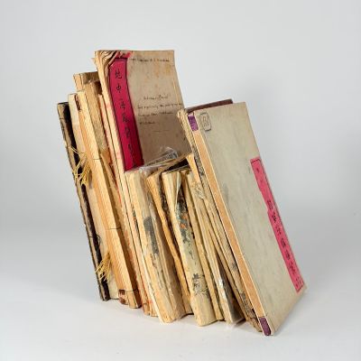 plusieurs vieux livres empilés sur une surface blanche