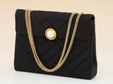 a black quilted purse with a gold chain strap