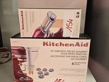 des boîtes contenant des accessoires KitchenAid rangées sur une étagère dans une cuisine