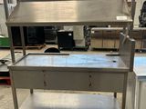 une photo d'une table de travail en acier inoxydable dans un entrepôt