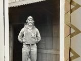 a black and white photo of a man standing in front of a garage