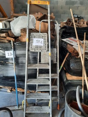 a pile of trash in a garage with a ladder