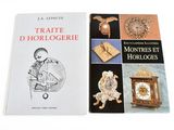 two books on a white table with a clock and other items