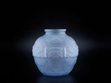 un vase bleu posé sur une surface noire