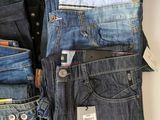 several pairs of men ' s jeans stacked on top of each other