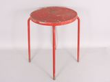 a small red table with a metal base and a red top