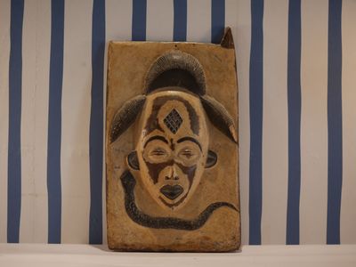 une photo d'une tenture murale sur laquelle figure un masque