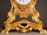 a gold clock sitting on top of a table