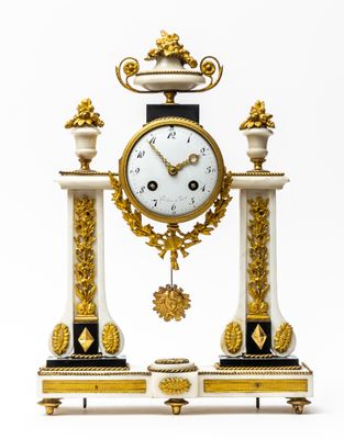 Une pendule portique en marbre blanc et bronze doré.