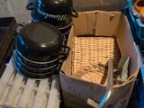 a metal sink that has a basket of pots and pans on top of it