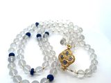 un collier de perles blanches et bleues muni d'un fermoir doré