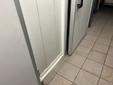 two refrigerators that are standing in a room