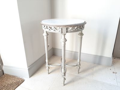 une table blanche avec un plateau en marbre dans une pièce