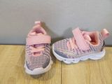 pink and gray sneakers with pink straps on a wooden floor