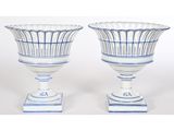 une paire de vases bleus et blancs posés sur une table blanche