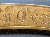 a close up of a gold plate with a name on it