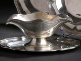 une assiette en argent posée sur une soucoupe et un plateau