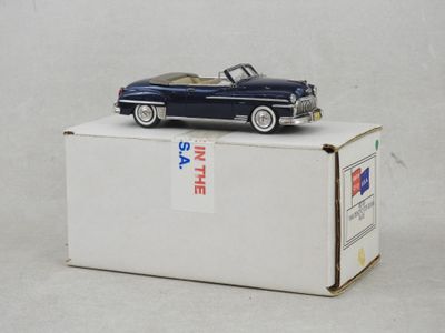 une petite voiture bleue posée sur une boîte