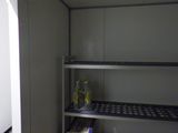 une étagère dans un coin d'une pièce, sur laquelle se trouvent de nombreux objets