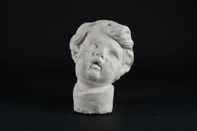 un gros plan sur la statue d'un enfant à l'air surpris