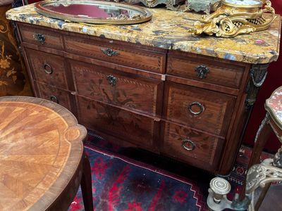 une commode en bois avec un plateau en marbre dans une chambre