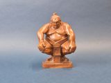 an image of a statue of a man sitting on top of a wooden block