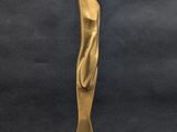 a gold statue of a woman standing on a wooden base