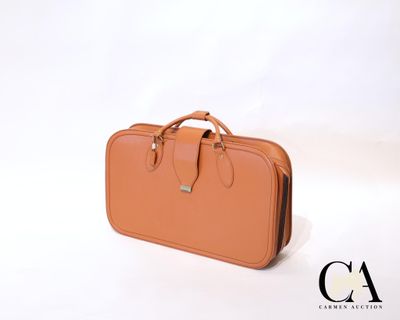 une valise beige posée sur une surface blanche